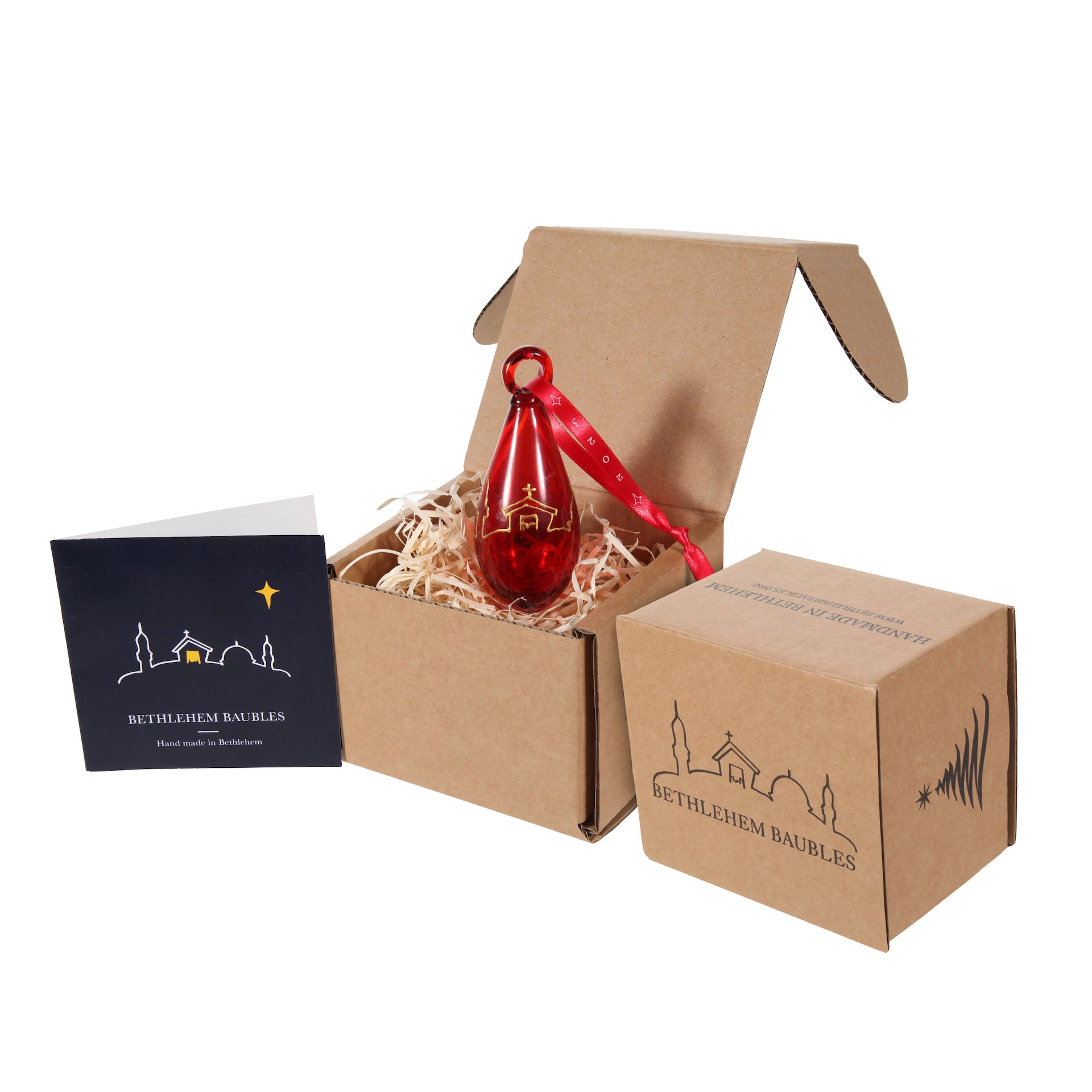 Red tear-shaped Christmas ornament with gold Bethlehem scene design in presentation box